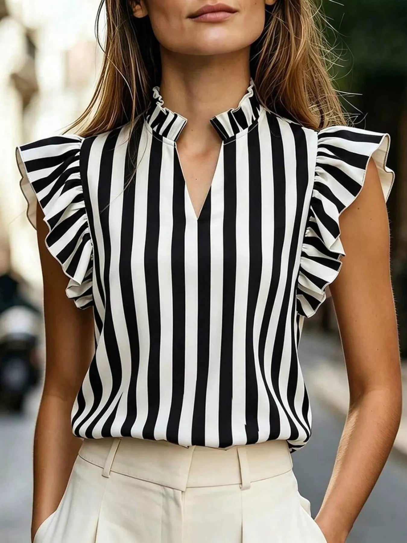 Printed ruffle sleeve blouse in 100% polyester with machine washable fabric and no stretch.