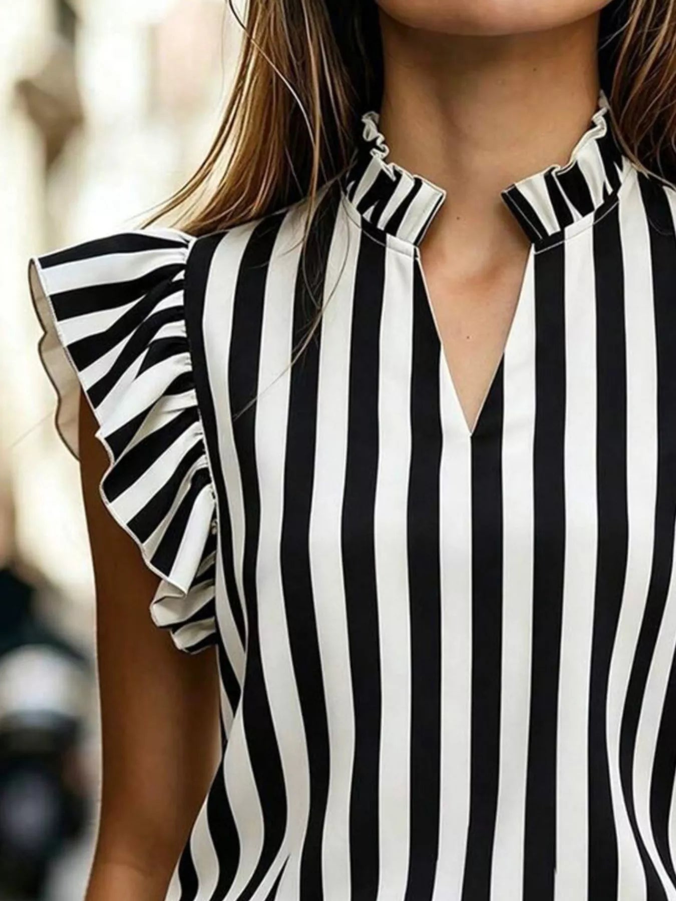 Printed ruffle sleeve blouse in 100% polyester with no stretch and ruffled sleeves.