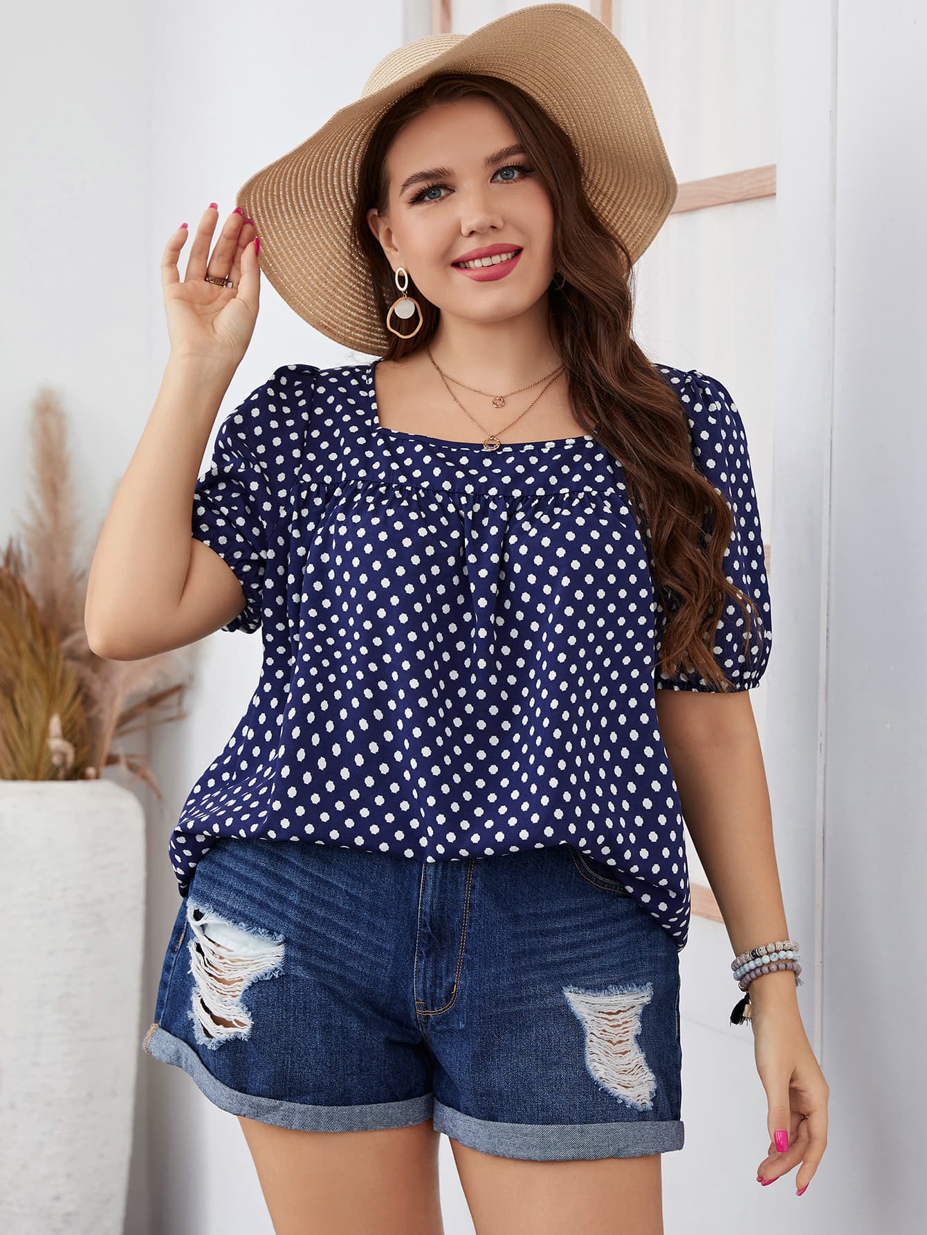Trendsi honey polka dot blouse for women in navy with white dots worn with denim shorts and sun hat